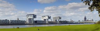 In der Ferne die Kölner Kranhäuser mit dem Rhein und der Wiese davor. 